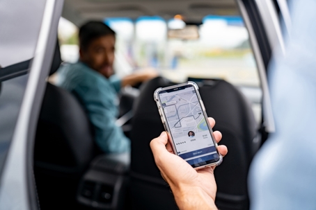 Man getting into a car he requested using a mobile app stock photo